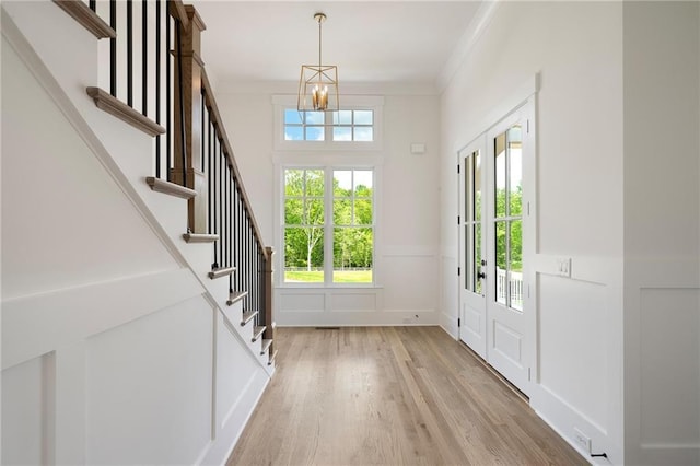 326 Reese Way, Ball Ground, GA 30107 - foyer entrance featuring a chandelier, crown molding, light wood-type flooring, stairs, and a decorative wall