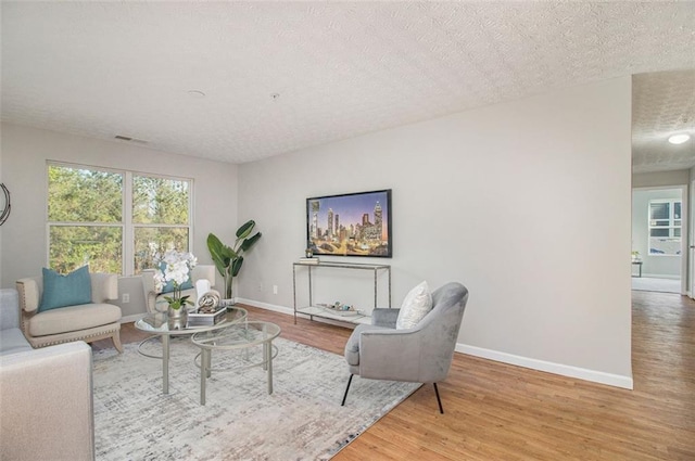 living room featuring a textured ceiling and light hardwood / wood-style floors