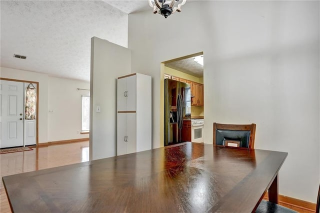 dining room with a high ceiling and a textured ceiling