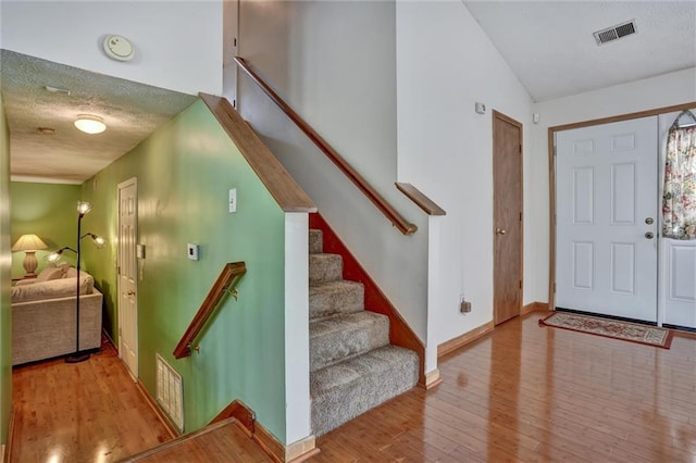 foyer with a textured ceiling and light hardwood / wood-style floors