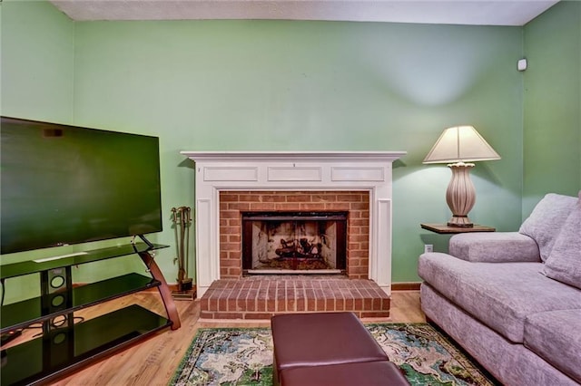 living area with light hardwood / wood-style floors and a brick fireplace