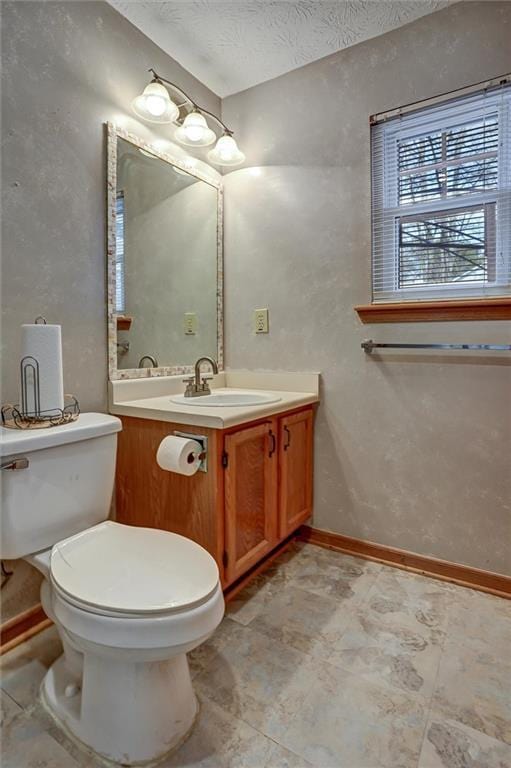 bathroom featuring vanity, toilet, and a textured ceiling