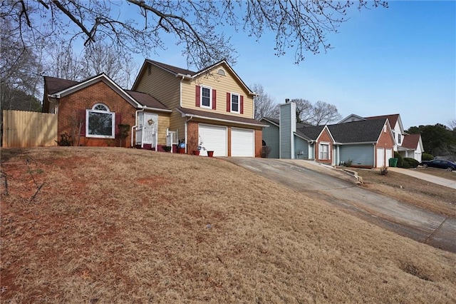 traditional home with fence, concrete driveway, a front lawn, a garage, and brick siding