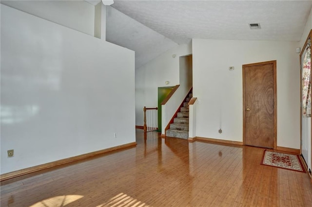 empty room featuring vaulted ceiling and light hardwood / wood-style floors