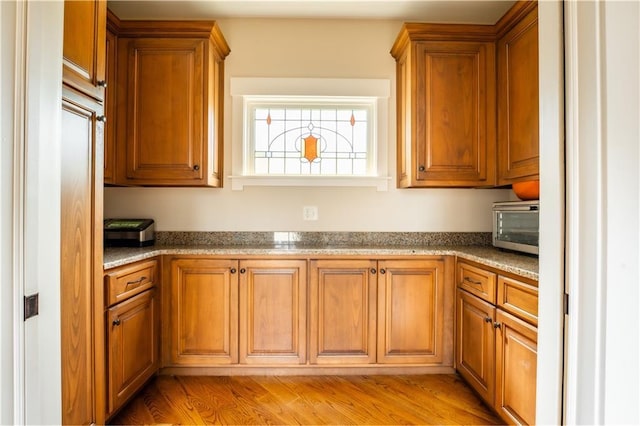 kitchen featuring dark stone countertops and light hardwood / wood-style flooring