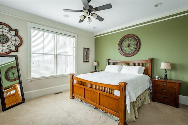 bedroom featuring ceiling fan, ornamental molding, and light colored carpet