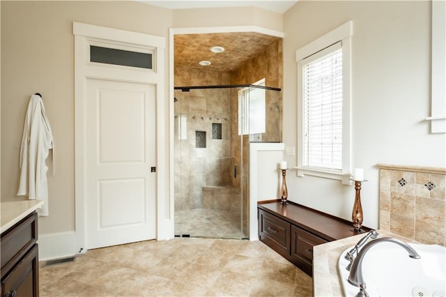 bathroom featuring vanity and independent shower and bath