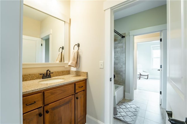 bathroom featuring tile patterned flooring, vanity, and tiled shower / bath