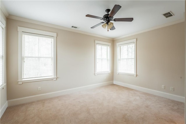 empty room featuring crown molding, ceiling fan, light carpet, and a wealth of natural light