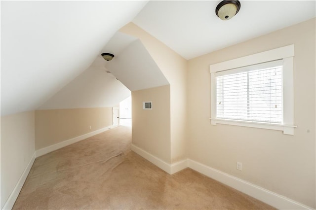 bonus room with lofted ceiling and light colored carpet