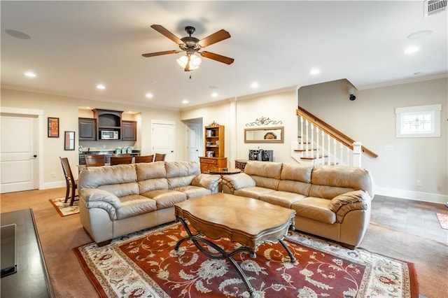 living room featuring crown molding and ceiling fan