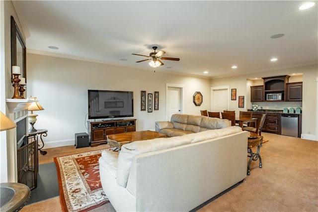 carpeted living room with ceiling fan and ornamental molding