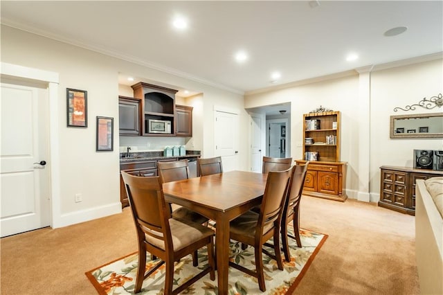 dining room featuring light carpet, sink, and ornamental molding