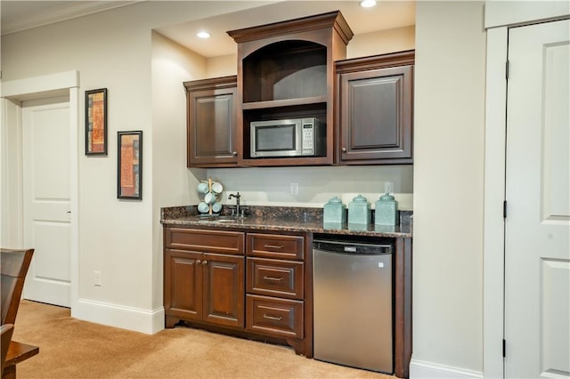 bar featuring light carpet, sink, ornamental molding, and appliances with stainless steel finishes