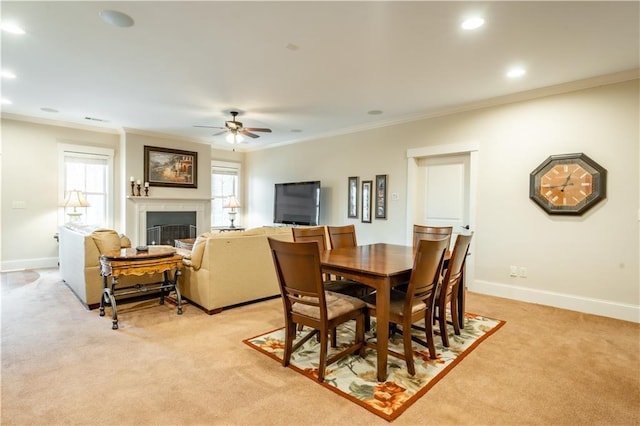 carpeted dining space featuring ornamental molding and ceiling fan