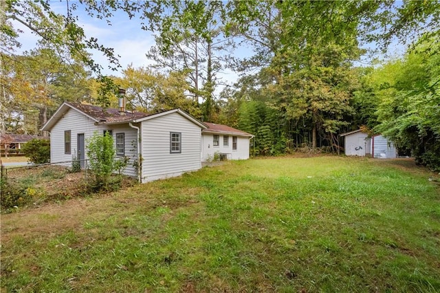 view of yard featuring fence and an outbuilding