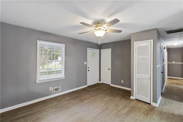 entrance foyer featuring wood finished floors, baseboards, a ceiling fan, and visible vents