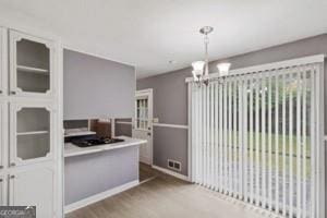 dining area featuring baseboards, a notable chandelier, and wood finished floors