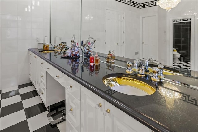 bathroom featuring vanity, an inviting chandelier, toilet, and tile walls