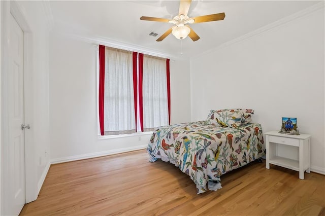 bedroom featuring hardwood / wood-style floors, ceiling fan, and crown molding