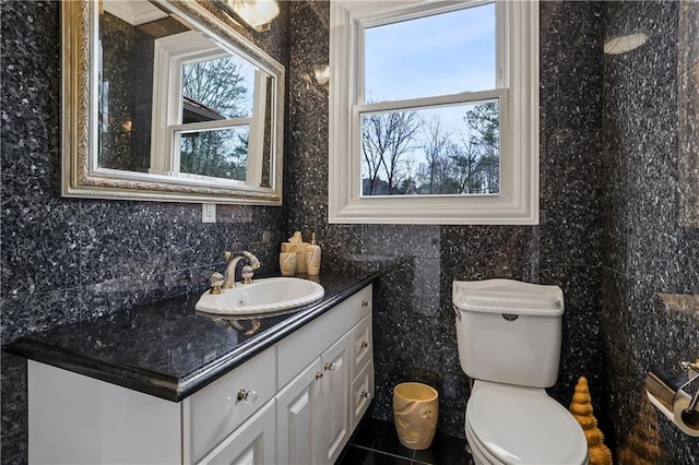 bathroom with tile patterned floors, vanity, tile walls, and toilet