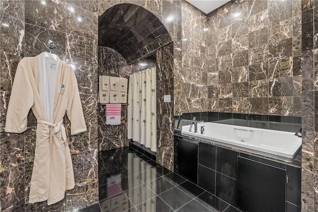 bathroom with tile walls and tiled tub