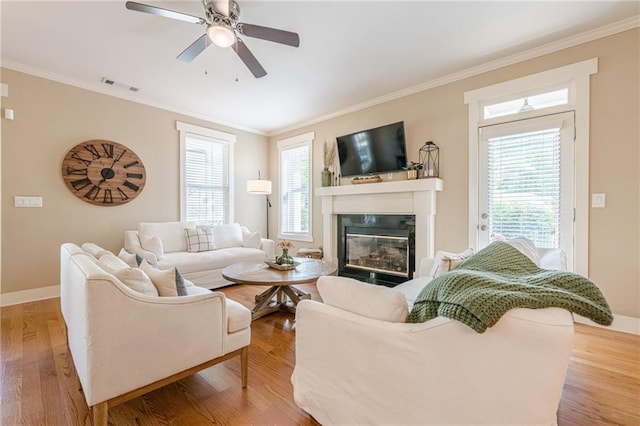 living room with crown molding, visible vents, and a wealth of natural light