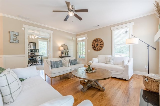 living area featuring light wood-style flooring, crown molding, and a ceiling fan