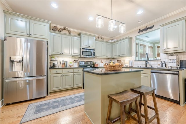 kitchen with a sink, ornamental molding, and stainless steel appliances