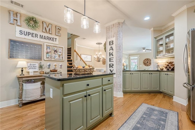 kitchen with freestanding refrigerator, crown molding, light wood-style floors, visible vents, and green cabinetry