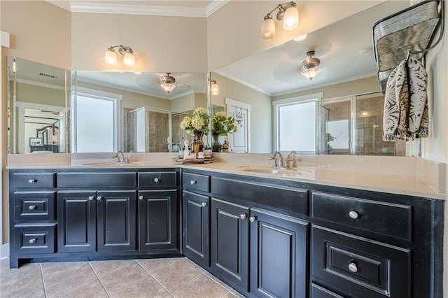 bathroom featuring a sink, a shower stall, tile patterned flooring, and crown molding