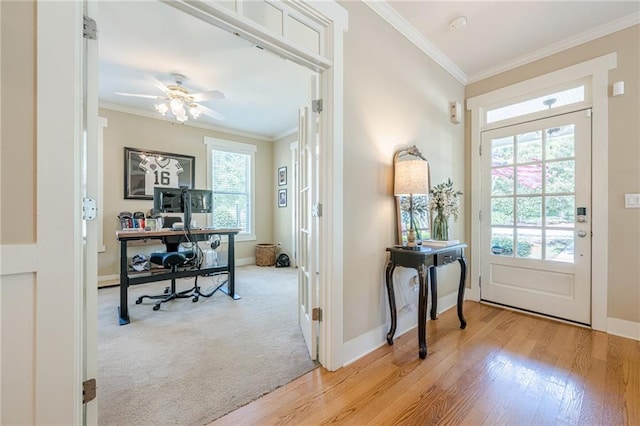 entrance foyer with light wood-style flooring, baseboards, and crown molding