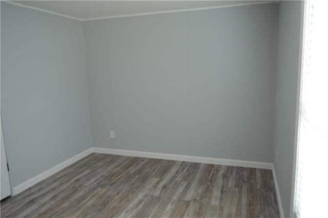 unfurnished room with hardwood / wood-style floors and crown molding