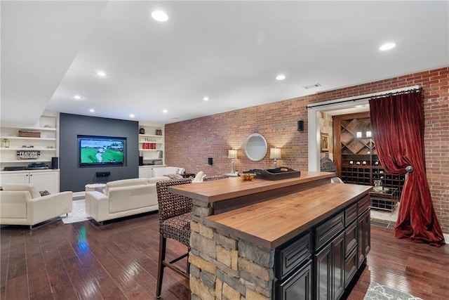 bar with butcher block countertops, dark hardwood / wood-style flooring, and brick wall