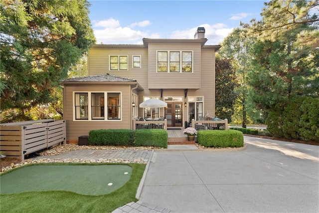 rear view of property featuring a wooden deck