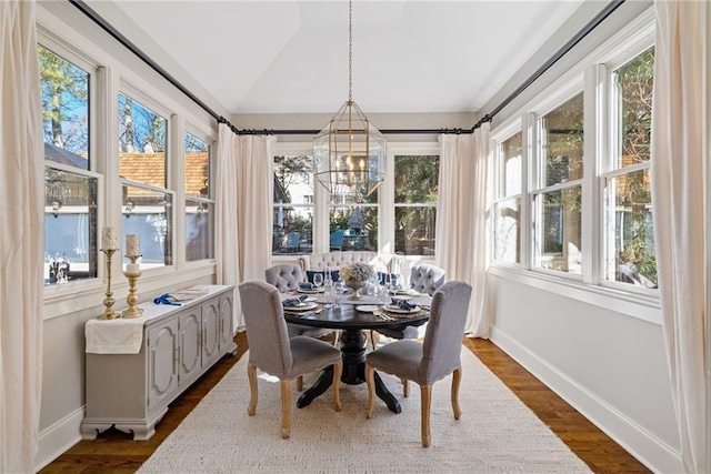 sunroom with vaulted ceiling, an inviting chandelier, and a wealth of natural light