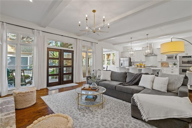 living room featuring french doors, crown molding, beam ceiling, hardwood / wood-style flooring, and a chandelier