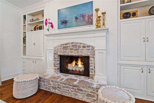 sitting room featuring built in shelves, a fireplace, dark hardwood / wood-style flooring, and ornamental molding