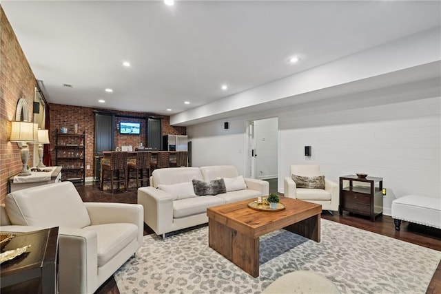 living room featuring brick wall and hardwood / wood-style flooring