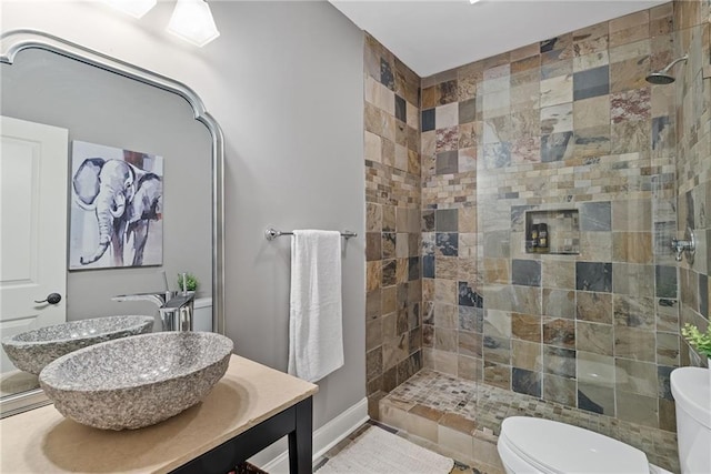 bathroom featuring tiled shower and toilet