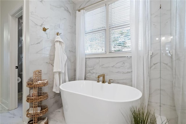 bathroom with a bath and tile walls