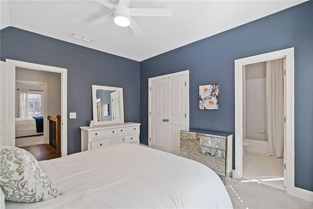 bedroom featuring a closet, ensuite bath, and ceiling fan