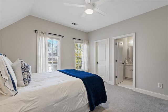 carpeted bedroom with ensuite bathroom, vaulted ceiling, and ceiling fan