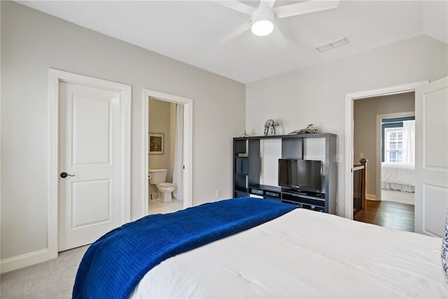 carpeted bedroom with connected bathroom and ceiling fan