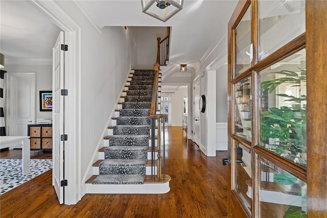 foyer entrance with dark hardwood / wood-style flooring and crown molding