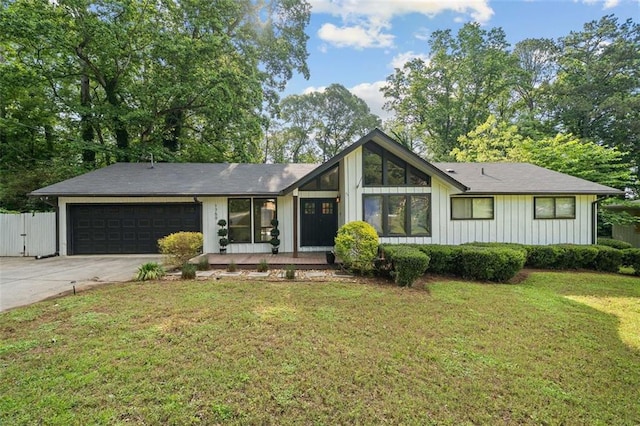 mid-century inspired home featuring a garage and concrete driveway