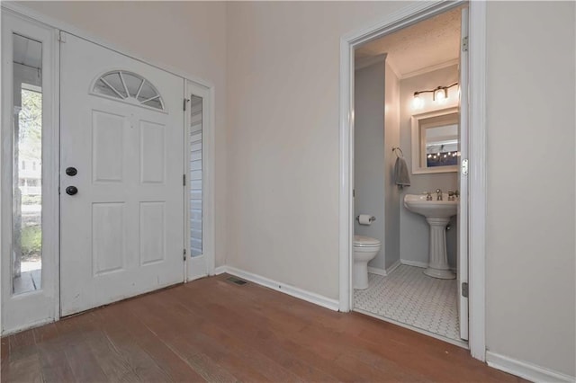 entryway with baseboards and wood finished floors