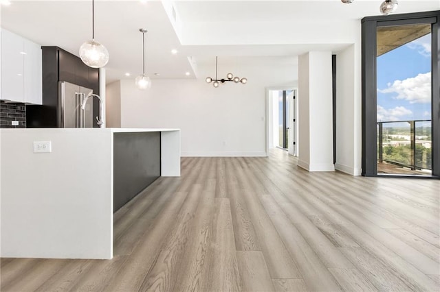 kitchen featuring light hardwood / wood-style flooring, white cabinets, and hanging light fixtures