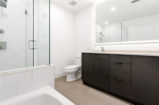 bathroom with tile patterned flooring, vanity, toilet, and an enclosed shower