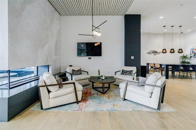 living room featuring an inviting chandelier and light hardwood / wood-style flooring